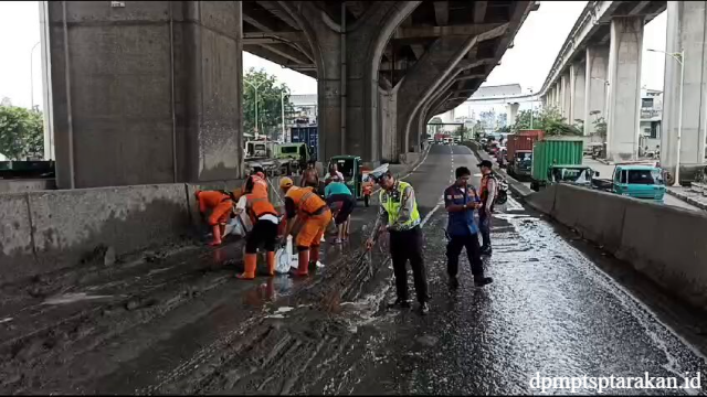 Petugas Bersihkan Jalan Layang Priok yang Tercemar Semen